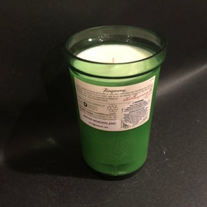 May include: A green glass candle jar with a white candle inside. The jar has a label that says "Tanqueray" and "Winter Wonderland".