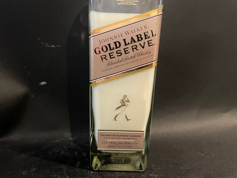 May include: A clear glass bottle with a white label that says "JOHNNIE WALKER. GOLD LABEL RESERVE. Blended Scotch Whisky DISTILLED, BLENDED AND BOTTLED IN SCOTLAND THE MASTER BLENDER'S RESERVE ESTT 1820 PRODUCT OF SCOTLAND"