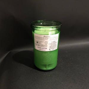 May include: A green glass candle jar with a white label that reads "Tangyberry Clean Cotton" and a recycling symbol.