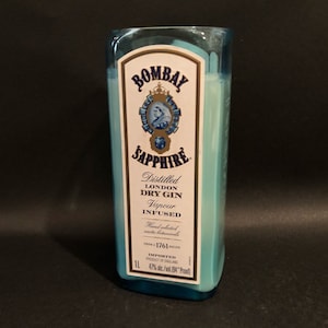 May include: A blue glass bottle with a white label that reads "Bombay Sapphire" and "Distilled London Dry Gin Vapour Infused". The label also includes the text "Hand selected exotic botanicals from 1761 recipes" and "Imported Product of England 47% Alc./Vol. (94 Proof)".