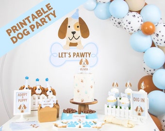 Puede incluir: Una mesa de fiesta con temática de perros con globos azules y marrones, un pastel con huellas de patas, cupcakes y un cartel que dice "Let's Pawty".