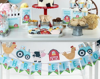 Puede incluir: Una decoración de fiesta de cumpleaños con temática de granja con un telón de fondo de granero rojo que dice "Happy Birthday". La mesa está decorada con un pastel, cupcakes, galletas y otras golosinas. Los globos en rojo, marrón y estampado de vaca se suman al ambiente festivo. Una pancarta dice "Three".