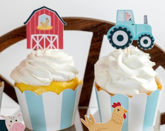 Könnte beinhalten: Ein mehrstöckiger Cupcake-Ständer mit vier Cupcakes, die mit Bauernhoftier-Toppern verziert sind. Die Cupcakes sind mit weißem Frosting überzogen und haben blaue und weiße gestreifte Cupcake-Förmchen. Der Ständer steht auf einem Strohboden.