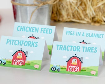 Könnte beinhalten: Vier blaue und weiße Lebensmitteletiketten mit einer Illustration einer roten Scheune und eines Traktors. Die Etiketten lauten "Chicken Feed", "Pitchforks", "Pigs in a Blanket" und "Tractor Tires".