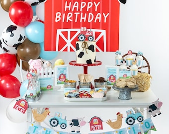 Könnte beinhalten: Ein Bauernhof-Geburtstagstisch mit einer roten Scheunenkulisse, einer Torte, die mit schwarz-weißen Kuhflecken verziert ist, und einem Banner mit der Aufschrift "Happy Birthday" und "Three". Der Tisch ist mit Bauernhoftier-Dekorationen geschmückt, darunter eine Kuh, ein Huhn und ein Traktor.