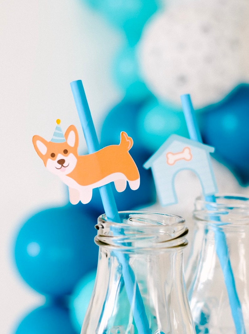 May include: Two blue and white striped paper straws with a dog and a doghouse design. The straws are in clear glass bottles.