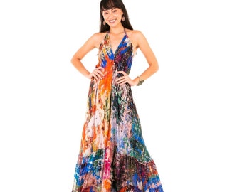Op de afbeelding: Een kleurrijke maxi-jurk met een halternek en een striksluiting. De jurk heeft een veelkleurige abstracte print en een gelaagde rok.