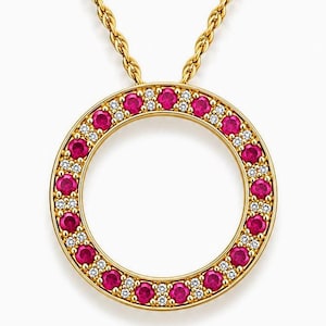 May include: A gold pendant necklace featuring a circular frame set with alternating round red gemstones and small clear white stones. The pendant hangs from a gold rope chain, creating a balanced design with a vibrant contrast between the gold metal.