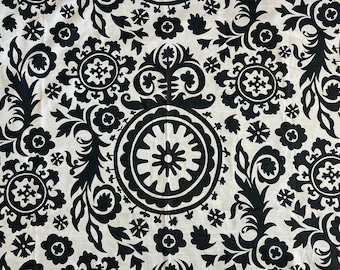 May include: Black and white fabric with a repeating pattern of stylized floral designs. The fabric features a large, circular design in the center.