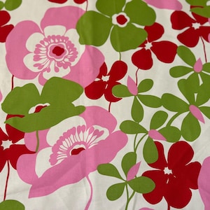 May include: A fabric with a floral pattern featuring large pink, red, and green flowers on a white background. The flowers have detailed centers and varying sizes, creating a vibrant and cheerful design.