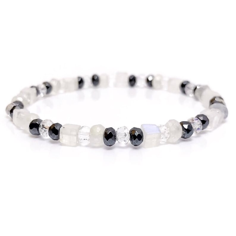 May include: A delicate bracelet made with white moonstone, clear crystal, and black hematite beads.
