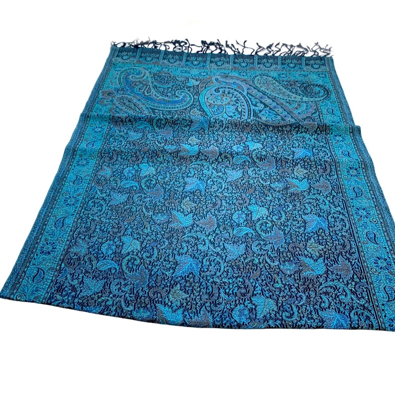May include: A blue and black paisley patterned scarf with fringed edges.