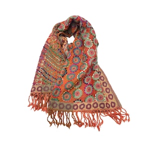 May include: A colourful scarf with a geometric pattern of circles and sequins. The scarf is made of a soft, lightweight fabric and has a fringed edge.