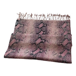 Puede incluir: Una bufanda de color rosa y negro con estampado de piel de serpiente y flecos.