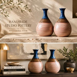 May include: A matching pair of ceramic vases featuring a rounded body and a narrow neck. The design includes horizontal bands of blue at the top, brown in the middle, and a light pink base with fine, dark horizontal lines throughout the surface.