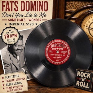 May include: A black 78 RPM shellac record by Fats Domino titled Don't You Lie to Me on the Imperial label. The record features a red center label with white text. A vintage photograph of Fats Domino and text about the record are visible.