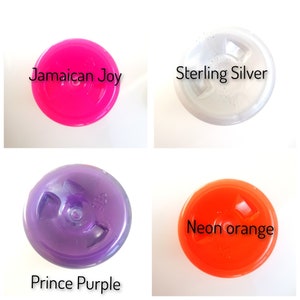 May include: Four round bottle caps in different colors: bright pink, silver, purple, and orange. The caps are labeled with the names "Jamaican Joy", "Sterling Silver", "Prince Purple", and "Neon orange".