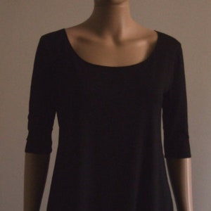 May include: A black, long-sleeved, scoop neck shirt with a slightly A-line shape.