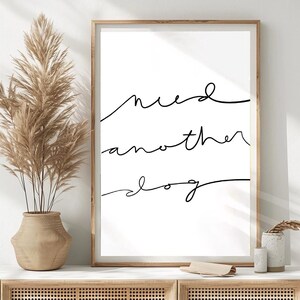 Peut inclure: Une impression murale d'art imprimable en noir et blanc avec le texte "need another dog" écrit en cursive.
