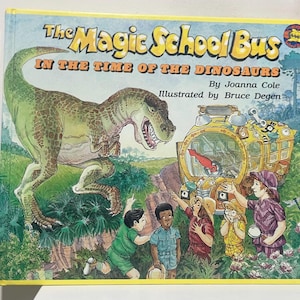 Könnte beinhalten: Kinderbuch mit dem Titel "The Magic School Bus in the Time of the Dinosaurs" mit gelbem Rand. Das Cover zeigt einen grünen Tyrannosaurus Rex, einen gelben Schulbus und mehrere Kinder. Illustriert von Bruce Degen.