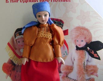 May include: Two Russian dolls wearing traditional folk costumes. The doll on the left is wearing a red and blue dress with a blue headscarf. The doll on the right is wearing a white fur coat with a black and white headscarf. The dolls are on a background with the text "Куклы в народных костюмах".