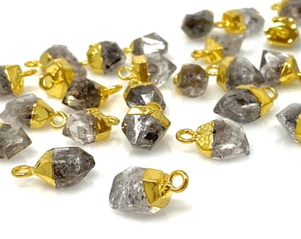 May include: A collection of gold-plated crystal point charms with a raw, natural look. The charms are faceted and have a clear, smoky quartz appearance. They are perfect for jewelry making or adding a touch of sparkle to any craft project.