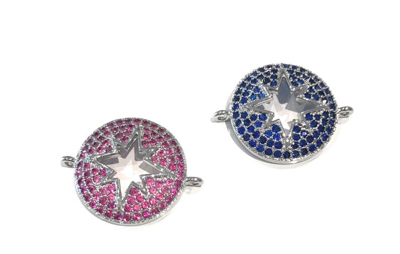 Pu&ograve; includere: Due ciondoli a forma di stella argentati con un centro trasparente. Un ciondolo &egrave; decorato con cristalli blu e l'altro con cristalli rosa.