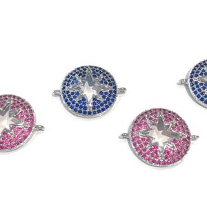 Pu&ograve; includere: Tre ciondoli in metallo argentato con un design a stella. I ciondoli sono decorati con strass blu e rosa. I ciondoli hanno un anello laterale per essere attaccati a un braccialetto o una collana.