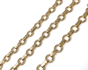 May include: Three gold chains with a textured, rectangular link design. Each chain has a series of round, open links.