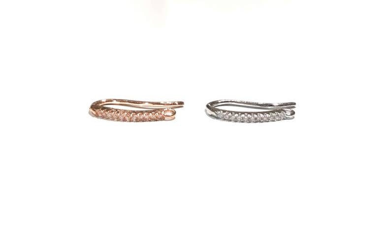 May include: Two ear cuffs, one in rose gold and one in silver, with a row of small clear stones.