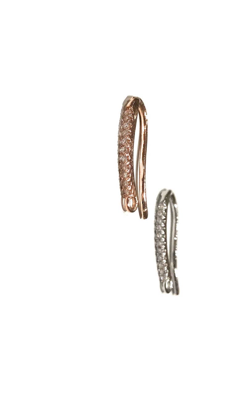 May include: Two jewelry clasps, one in rose gold and one in silver, both with a row of clear cubic zirconia stones.