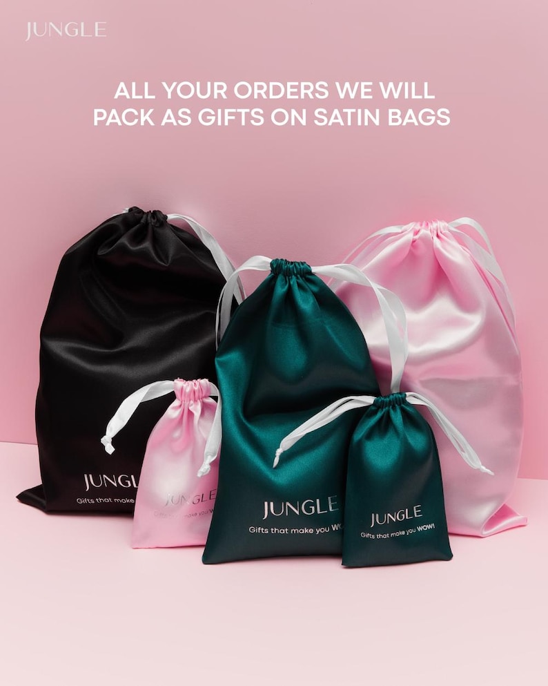 May include: A collection of satin gift bags in black, pink, and teal, each with white drawstrings. The bags are printed with the word "JUNGLE" and the phrases "Gifts that make you WOW!" and "Gifts that make you W". The text "ALL YOUR ORDERS WE WILL PACK AS GIFTS ON SATIN BAGS" is also visible.