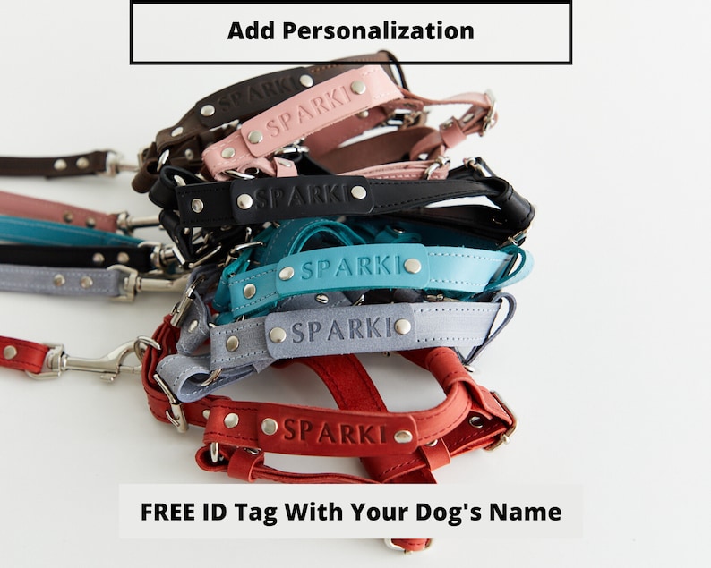 May include: A selection of colourful dog harnesses, each with the name "SPARKI" embossed on the leather. The harnesses come in shades of red, grey, teal, black, pink, and brown. The image also includes the text "Add Personalization" and "FREE ID Tag With Your Dog's Name".