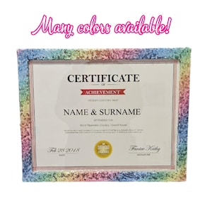 May include: A certificate of achievement in a frame with a rainbow sequin border. The certificate has the text "Certificate of Achievement" and space for a name and signature. The text "Many colors available!" is above the frame.