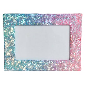 May include: A rectangular iridescent photo frame with a white border. The frame has a holographic finish with a blue, pink, and purple color gradient.