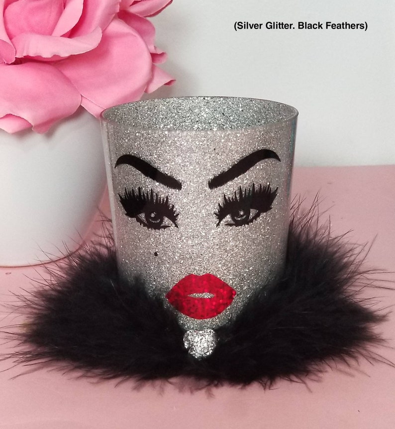 May include: Silver glitter makeup brush holder with black feather trim and a black and white face with red lips design. (Silver Glitter. Black Feathers)