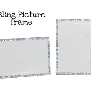 May include: Two rectangular picture frames with clear centers and borders lined with iridescent rhinestones. The text "Bling Picture Frame" is above the frames. One frame is horizontal, the other is vertical.
