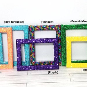 May include: A collection of six rectangular picture frames covered in sparkling sequins in various colors including Neon Orange, Icey Turquoise, Rainbow, Purple, Emerald Green, and Iridescent Yellow, each labeled with its respective color name.