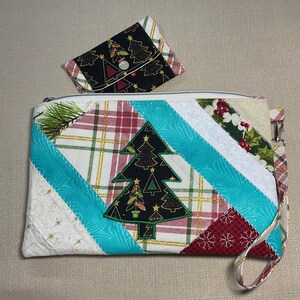 Könnte beinhalten: Eine rechteckige Stofftasche mit Handschlaufe und diagonalem Patchwork-Design aus Karomustern, Türkis und weihnachtlichen Motiven mit einer zentralen Weihnachtsbaum-Applikation. Ein passendes kleines Münztäschchen mit Druckknopf ist enthalten.