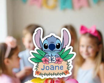 Pode incluir: Um topo de bolo azul com o personagem Stitch, com um design floral e uma placa que diz "13 Joane".