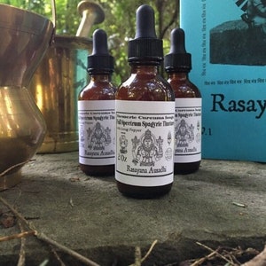 Könnte beinhalten: Drei bernsteinfarbene Glasflaschen mit Tropfern, gefüllt mit einer dunklen Flüssigkeit. Die Flaschen sind mit "Turmeric Curcuma Longa Full Spectrum Spagyric Tincture with Long Pepper Rasayana Ausadhi 2 oz." beschriftet.