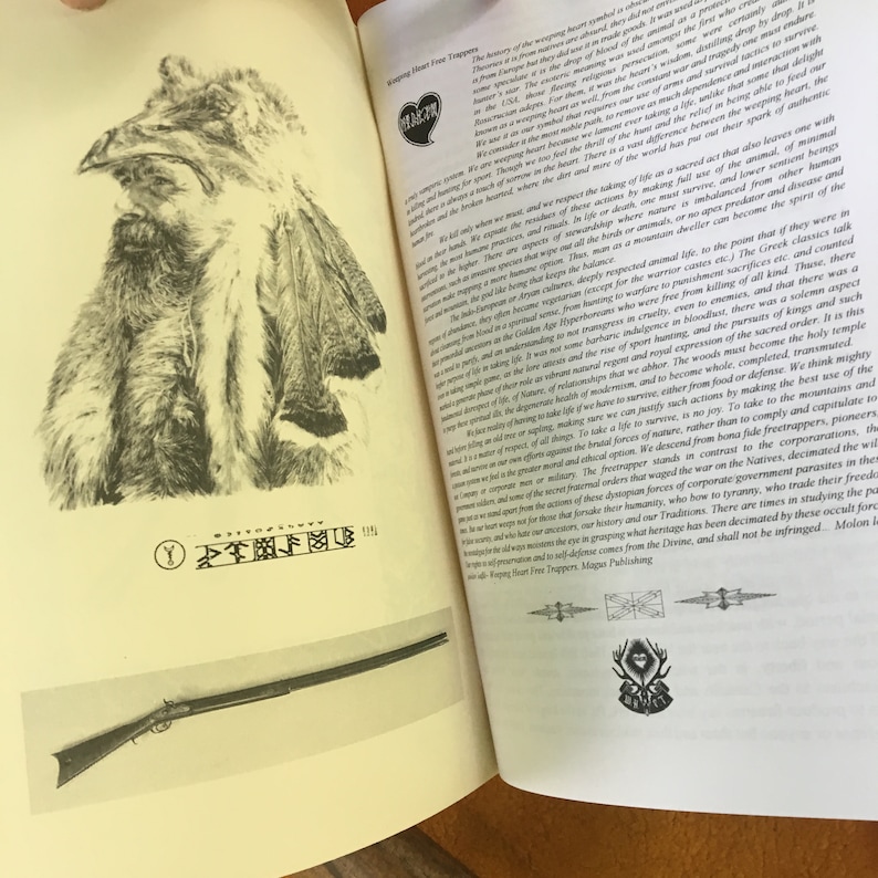 May include: Open book with a black and white illustration of a Native American man wearing a fur hat and coat. The book is titled "Wapping Heart Free Trappers". The text on the page discusses the history of the trapping trade and the importance of respecting nature and wildlife.