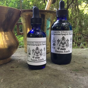 May include: Two blue glass bottles with dropper tops, labelled "Ashwagandha Withania somnifera Full Spectrum Spagyric Tincture" and "Rasayana Ausadhi". The bottles are 2 oz and 4 oz, respectively.