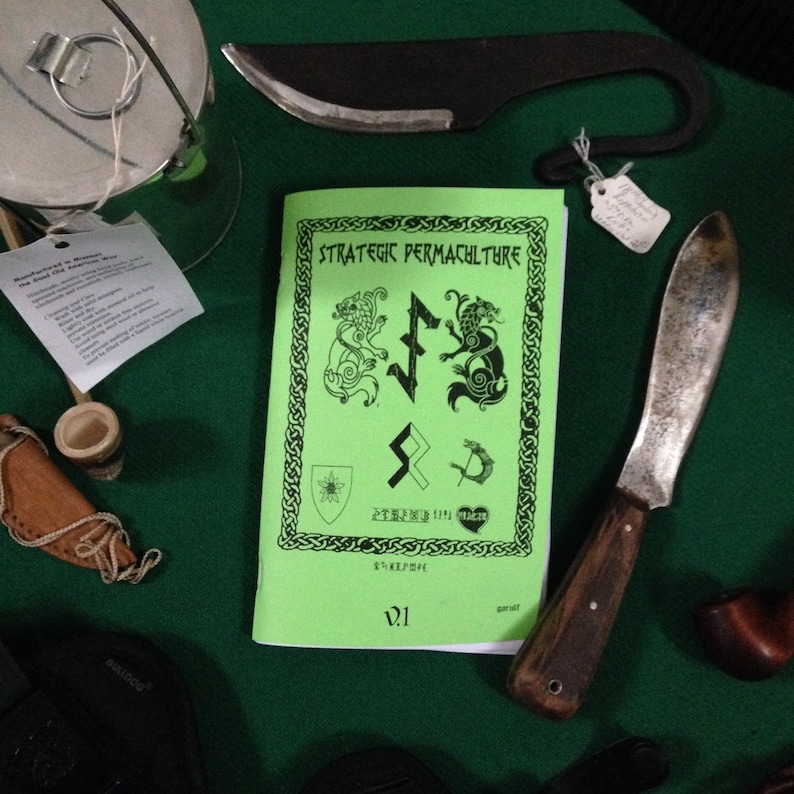 May include: A collection of handcrafted items, including a knife with a wooden handle, a black curved blade, and a green booklet titled "Strategic Permaculture." The booklet features Celtic-style illustrations and text. Other items include a small wooden pipe and a leather sheath.