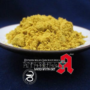 Puede incluir: Primer plano de un montón de polvo amarillo en un plato de cerámica blanca. El polvo es un suplemento herbal natural. El texto "HYPERBOREAN LABORATORIES" y "ASATRU APOTHECARY" es visible en la imagen.