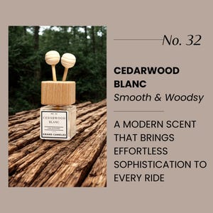 May include: A car air freshener with a wooden top and two spherical wooden diffusers. The clear glass bottle has a label that reads "CEDARWOOD BLANC". The text "No. 32" is also visible. The product is designed to bring sophistication to every ride.
