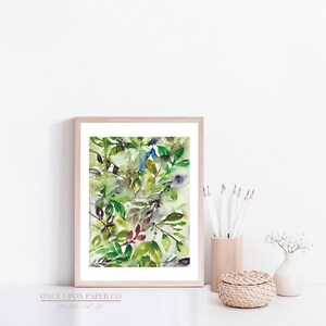 May include: A framed watercolor painting of green leaves and branches in shades of green, blue, and brown. The painting is set against a white background.
