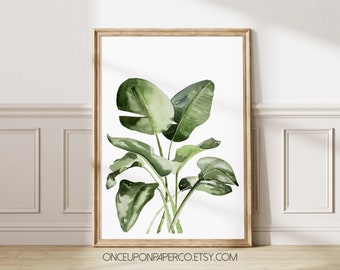 May include: A watercolor painting of a green tropical plant with large leaves in a light wood frame. The background is white. The text "ONCEUPONPAPERCO.ETSY.COM" is at the bottom of the image.