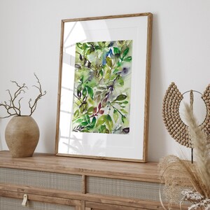 May include: A framed watercolor painting of green and blue leaves in a wooden frame. The painting is on a wooden shelf with a vase of dried branches and a wooden beaded necklace.