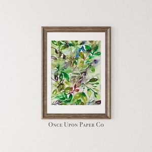 May include: A framed watercolor painting of green, blue, and red leaves. The painting is titled "Once Upon Paper Co."